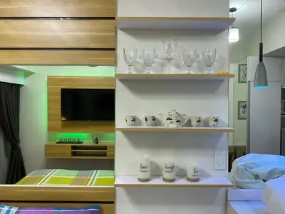 a room with shelves with wine glasses and a bed at Fresh Air in Heart of Makati in Manila