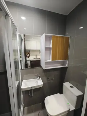 a bathroom with a toilet and a sink and a mirror at Fresh Air in Heart of Makati in Manila