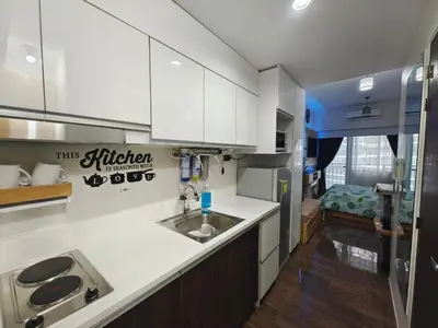 a kitchen with white cabinets and a sink at Fresh Air in Heart of Makati in Manila