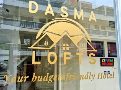 a sign on a window of a building with a house at Dasma Lofts Hotel near Dela Salle Dasma in Dasmariñas