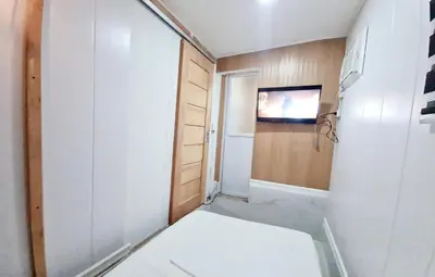 a small room with a toilet and a television at Dasma Lofts Hotel near Dela Salle Dasma in Dasmariñas