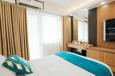 a hotel room with a bed and a television at Hawaii Suite by Guest Reservations Manila in Manila