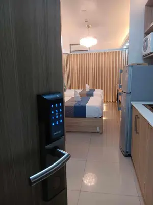 a room with a bedroom with a bed and a kitchen at Hawaii Suite by Guest Reservations Manila in Manila