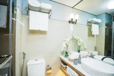 a bathroom with a sink and a toilet and a mirror at Hawaii Suite by Guest Reservations Manila in Manila