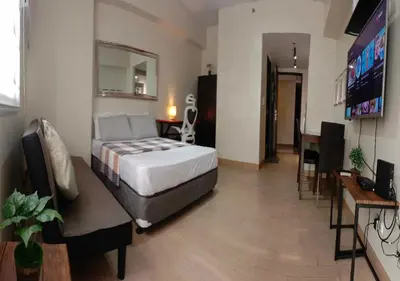 a hotel room with a bed and a dining room at SonSon at Manhattan Plaza Tower 1, Araneta, Cubao, Quezon City in Manila