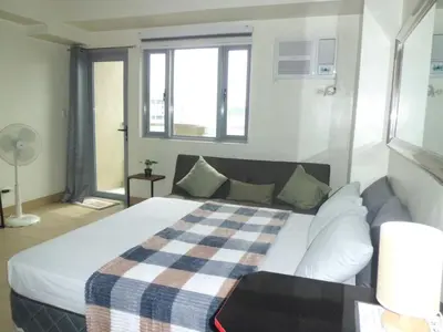 a bedroom with a bed with a checkered blanket at SonSon at Manhattan Plaza Tower 1, Araneta, Cubao, Quezon City in Manila