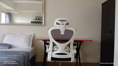 a white chair sitting on a desk next to a bed at SonSon at Manhattan Plaza Tower 1, Araneta, Cubao, Quezon City in Manila