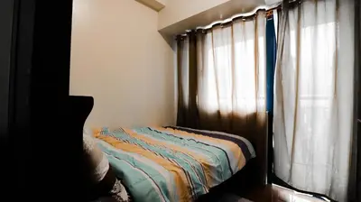 a bedroom with a bed next to a window at Smart Cozy Home Air Residences Makati in Manila