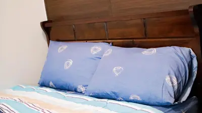 two blue pillows sitting on top of a bed at Smart Cozy Home Air Residences Makati in Manila