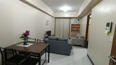 a living room with a table and a couch at Hilander's Condotel near Terminal 3 Airport in Manila