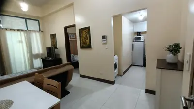 a living room with a couch and a refrigerator at Hilander's Condotel near Terminal 3 Airport in Manila