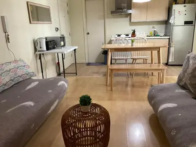 a living room with a couch and a kitchen with a table at SHAW BLVD 69 sqm 2 bdrm w/ WiFi, parking, across Shangrila Mall in Manila