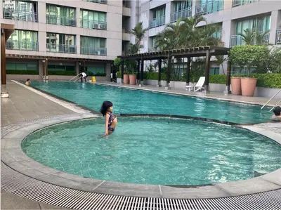 a young child is standing in a swimming pool at SHAW BLVD 69 sqm 2 bdrm w/ WiFi, parking, across Shangrila Mall in Manila
