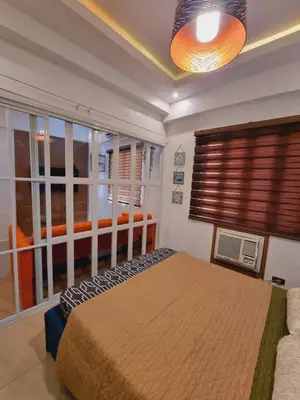 a bedroom with a bed and a large window at Modern Minimalist Condo near Airport in Manila