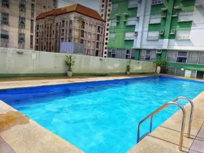 a large blue swimming pool with buildings in the background at 2BR Loft unit in Manila