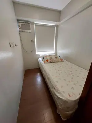 a small room with a bed and a window at 2BR Loft unit in Manila