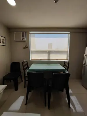 a dining room with a table and chairs and a window at 2BR Loft unit in Manila