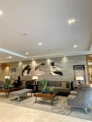 a living room with couches and tables and a person at LuxeRN Suite at S Residences in Manila