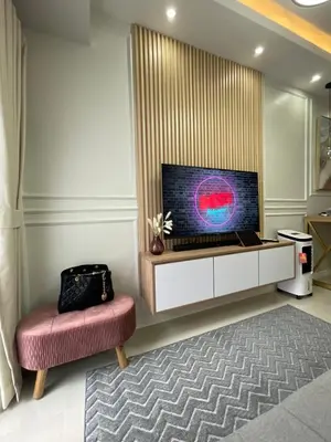 a living room with a large television and a chair at LuxeRN Suite at S Residences in Manila