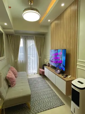a living room with a couch and a flat screen tv at LuxeRN Suite at S Residences in Manila
