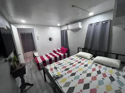 a bedroom with a bed and a couch in it at 9 Guest - Unit 1 House Type in Pasong Mannga