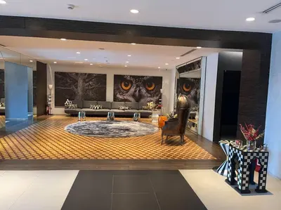 a living room with a large room with a large oval room with owl paintings at Aveline Suites Aesthetic Skydeck View ACQUA Private Residences near Rockwell Makati in Manila