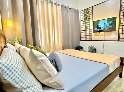 a bedroom with a bed with a tv on the wall at Bea’s Transient (Condo Studio Room for 2!) in Manila