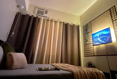 a bedroom with a bed and a window with curtains at Bea’s Transient (Condo Studio Room for 2!) in Manila