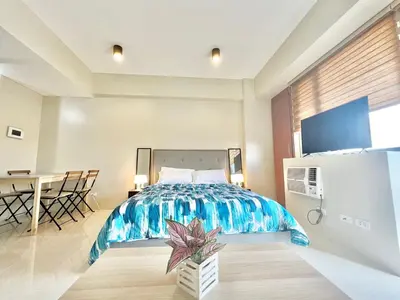 a bedroom with a large bed and a table at Kiel 4-Star Condo Hotel Near NAIA Manila Airport Terminal in Manila