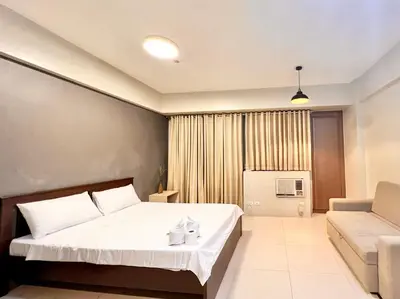 a bedroom with a large bed and a couch at Kiel 4-Star Condo Hotel Near NAIA Manila Airport Terminal in Manila