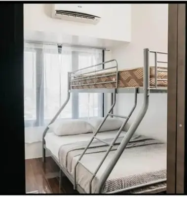 two bunk beds in a room with a window at 2 Bed 2 Bath condo in Air Residences in Manila