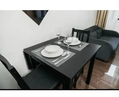a black dining table with two glasses and plates on it at 2 Bed 2 Bath condo in Air Residences in Manila
