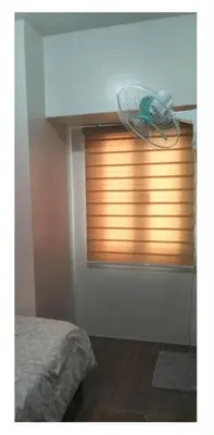 a bedroom with a window with a fan at 2 Bed 2 Bath condo in Air Residences in Manila