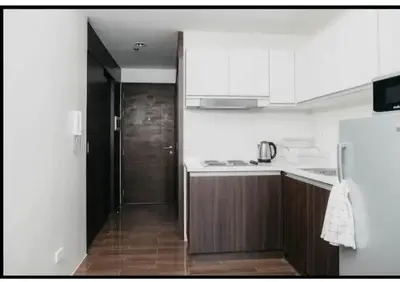 a kitchen with a sink and a refrigerator at 2 Bed 2 Bath condo in Air Residences in Manila