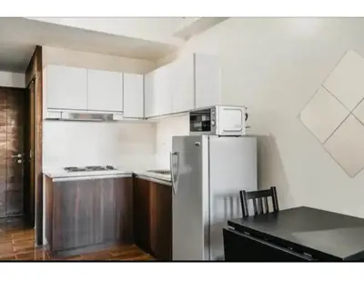 a kitchen with a refrigerator and a table in it at 2 Bed 2 Bath condo in Air Residences in Manila