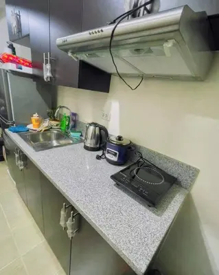 a kitchen counter with a sink and a microwave at Kasara De Ulap BEST Staycation - 25th Floor City View - Pool & Fast Wi-Fi in Manila