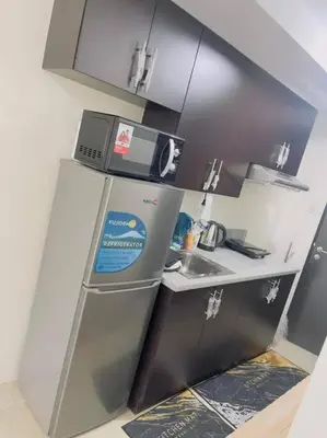 a small kitchen with a refrigerator and a sink at Kasara De Ulap BEST Staycation - 25th Floor City View - Pool & Fast Wi-Fi in Manila