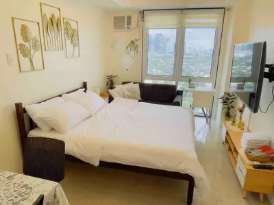 a bedroom with a large white bed and a window at Kasara De Ulap BEST Staycation - 25th Floor City View - Pool & Fast Wi-Fi in Manila