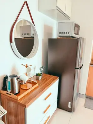 a kitchen with a refrigerator and a counter with a mirror at Studio Unit Viceroy Residences McKinley Hill BGC in Manila