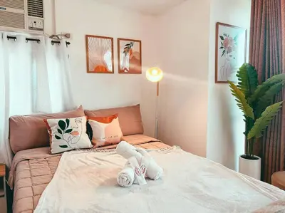 a bedroom with a bed with towels on it at Studio Unit Viceroy Residences McKinley Hill BGC in Manila