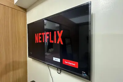 a television with the netflix sign on a wall at Tropical Balcony Pool View, 14th floor, MOA, Netflix, Airport at Shell Residence in Manila