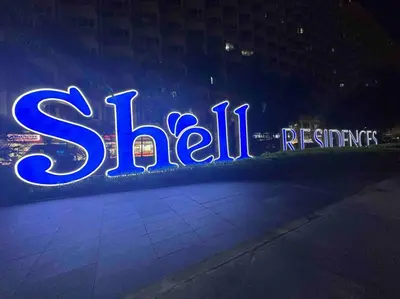 a neon sign that says skilrets on the side of a building at Tropical Balcony Pool View, 14th floor, MOA, Netflix, Airport at Shell Residence in Manila
