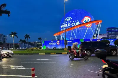 a person riding a motorcycle in front of a world cup sign at Tropical Balcony Pool View, 14th floor, MOA, Netflix, Airport at Shell Residence in Manila
