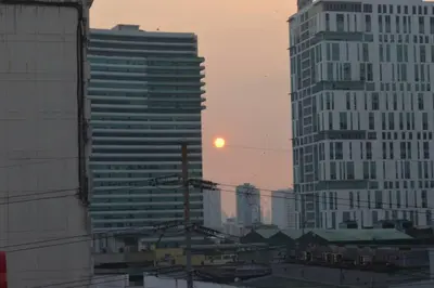 a view of a city with tall buildings and the sunset at Cozy Studio with Beautiful View & FREE Netflix Access in Manila