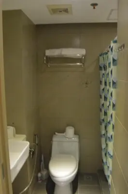 a bathroom with a toilet and a sink at Cozy Studio with Beautiful View & FREE Netflix Access in Manila