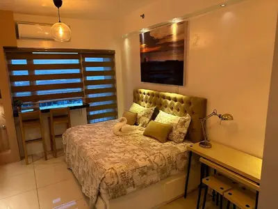 a bedroom with a bed and a desk with a desk at Breeze Residences with Ocean view by Bmars in Manila