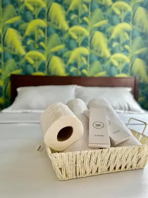 a basket with two rolls of toilet paper on a bed at 2Bedroom Loft Type Unit in BGC by K Suites in Manila