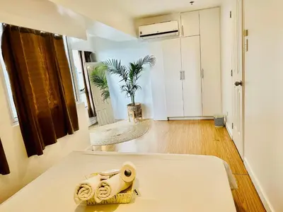 a room with a bed with towels on it at 2Bedroom Loft Type Unit in BGC by K Suites in Manila