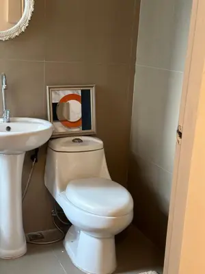 a bathroom with a white toilet and a sink at 2Bedroom Loft Type Unit in BGC by K Suites in Manila