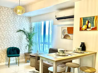 a living room with a table and chairs at 2Bedroom Loft Type Unit in BGC by K Suites in Manila